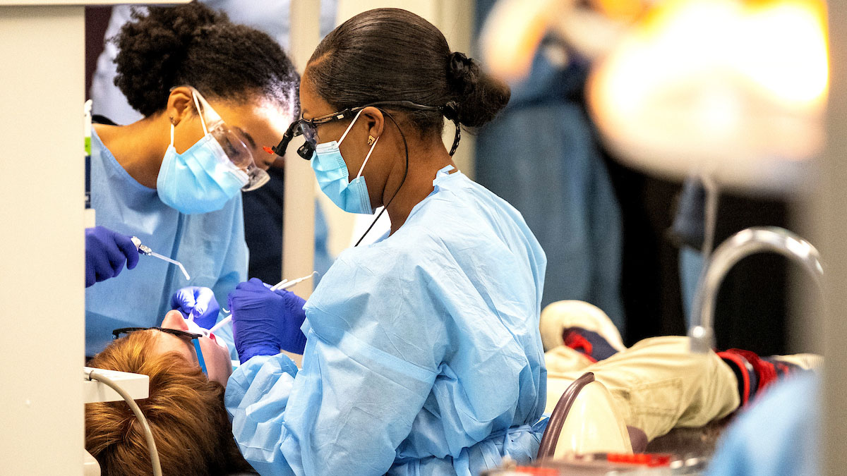 Dental students work on patient